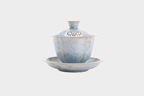 淡い青色の結晶釉が施された蓋碗セット。蓋には透かし彫りの穴があり、全体的に祥雲のような模様が見える。