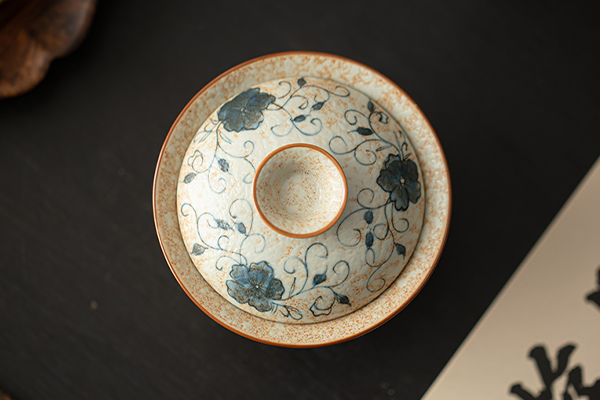 上から見た、青花火石紅の唐草蓮文様が描かれた二才蓋碗。蓋が本体に乗せられており、繊細な模様が際立つ。