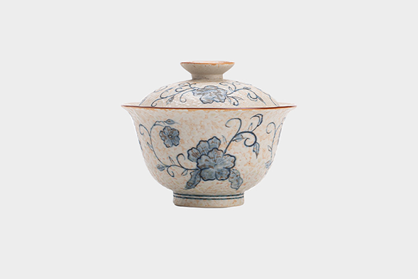 白い背景に置かれた、青花火石紅の唐草蓮文様が描かれた二才蓋碗。蓋が閉じられた状態で、その美しい模様がはっきりと見える。