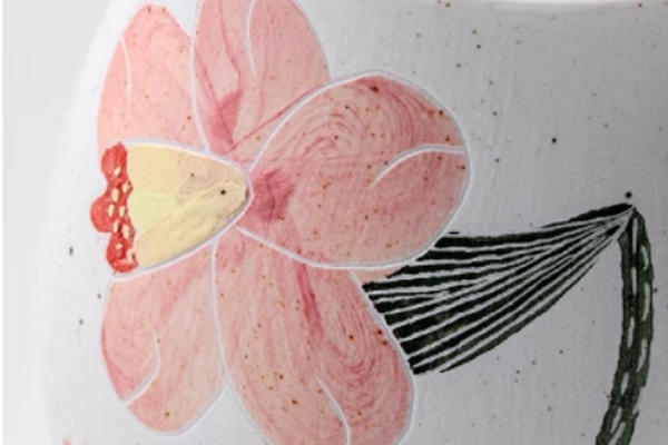 夕顔の花の陶磁器茶器に描かれた花の模様をクローズアップした画像。ピンク色の花びらと、線画で描かれた葉のディテールがはっきりと見える。